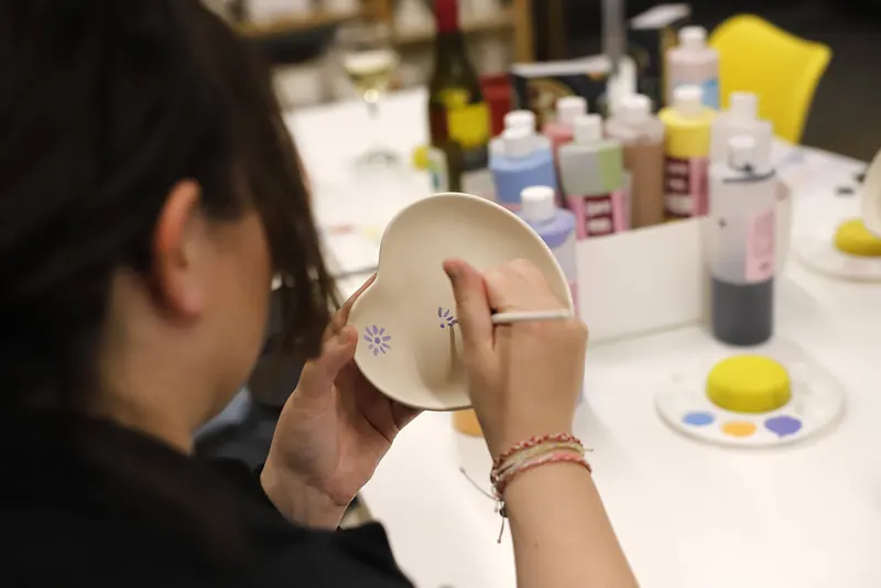 Close-up of hands decorating a small piece