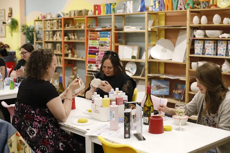 Guests making at long tables in the studio